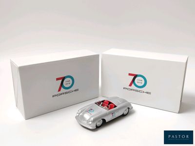 une petite voiture argentée devant une boîte blanche