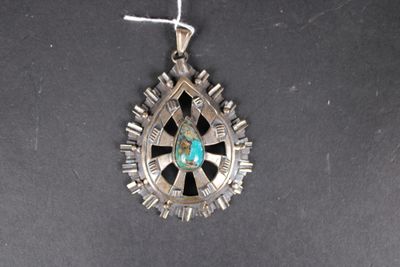 un gros plan sur un collier en argent orné d'une pierre turquoise au centre