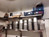 many pots and pans stacked on a shelf in a kitchen