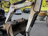 an image of a small excavator parked in a parking lot