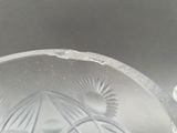 a clear glass bowl with a sun design on it