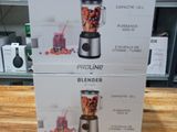deux cartons contenant des mixeurs posés sur une table en bois