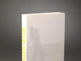 un livre blanc avec des lettres jaunes, posé sur une table