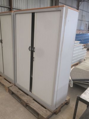 une grande armoire blanche dans un entrepôt où se trouvent de nombreuses palettes