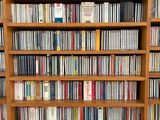 a book shelf full of dvds and cds in a room