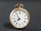 une montre de poche en or avec des chiffres romains sur le cadran