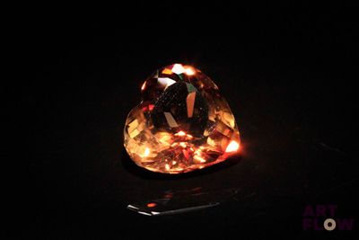 a close up of a yellow diamond on a black surface