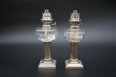 une paire de bougeoirs en argent et cristal sur fond noir