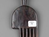 a wooden comb with a tag on it on a gray surface