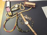 une table sur laquelle sont posées une montre, des bracelets et d'autres objets