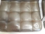 a brown leather chair that has a metal frame