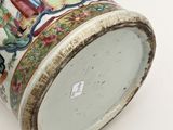 a vase with a painting on it sitting on a table