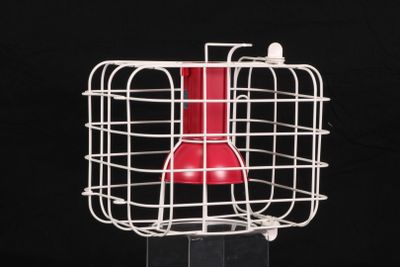 un objet rouge dans une cage blanche sur fond noir