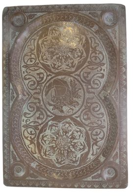 une vieille plaque métallique ornée d'un motif décoratif