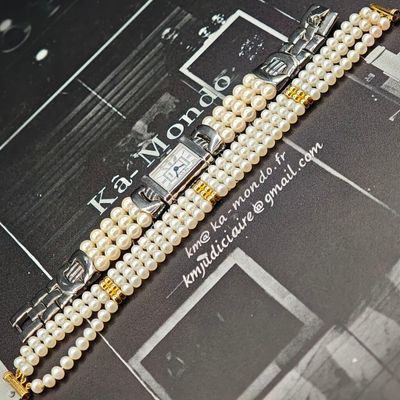 une photo d'un bracelet de perles sur lequel est posée une montre
