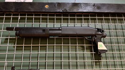 une arme posée sur un râtelier dans une pièce
