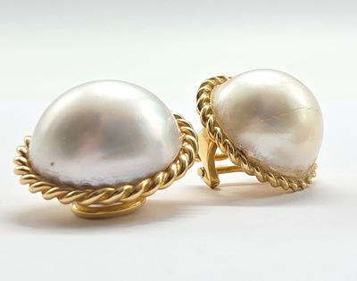 une paire de boucles d'oreilles en perles et en or sur fond blanc