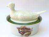 a white duck sitting on top of a green and white bowl