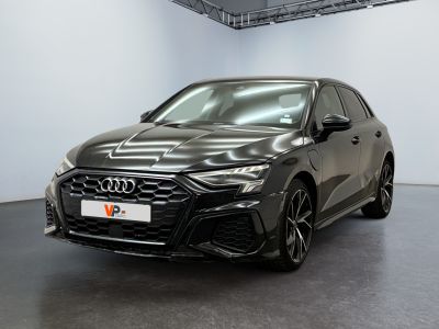 Une Audi RS4 noire est garée dans une grande pièce