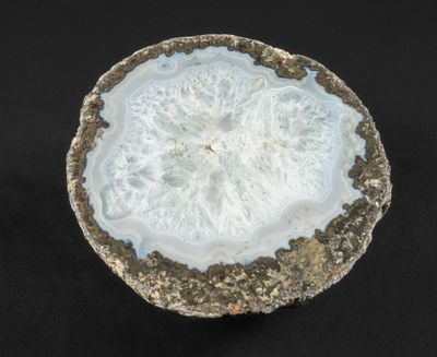 une photo d'un morceau de roche orné d'un motif blanc et doré