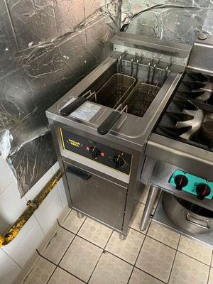 une photo d'une cuisine professionnelle équipée de deux friteuses et d'un évier