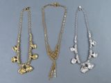 trois colliers en or et en argent ornés de fleurs et de feuilles