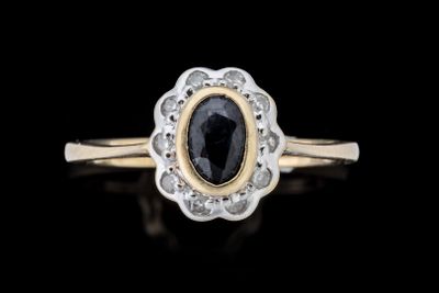 un gros plan d'une bague sertie d'un diamant noir posée sur une surface noire