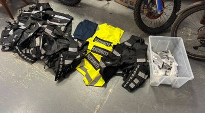many different types of clothing on the floor next to a bike