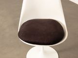 a white chair with a brown cushion on top of it