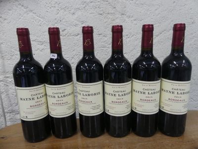 six bouteilles de vin rouge sont alignées sur une table en bois