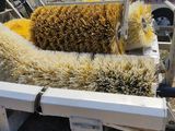 a truck that has a bunch of brushes in the back of it