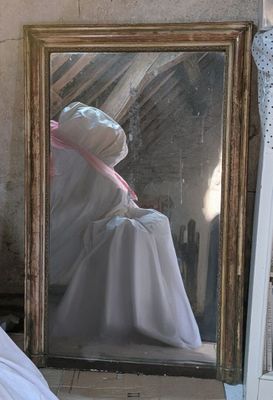 a white dress on a mannequin in front of a mirror
