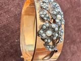 un gros plan d'un bracelet en or orné de perles