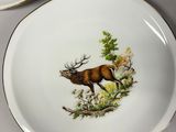 three plates with a picture of a deer on them on a table