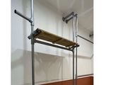 a picture of a bathroom with a wooden shelf and pipes