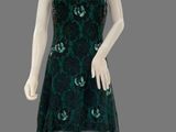 a mannequin dressed in a green dress on a gray background