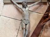 a statue of jesus on the cross next to a crucifix
