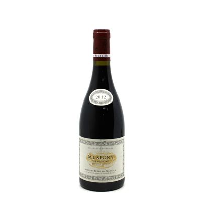 the bottle of wine is sitting on a white surface