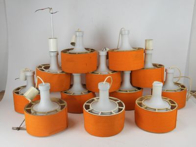 a lot of orange lamps that are on a white table