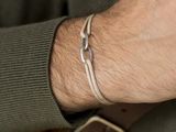 a man that is wearing a bracelet on his wrist