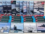 plusieurs livres de magazines maritimes sont empilés sur une table