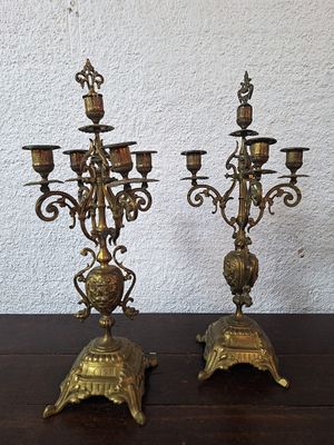 pair of antique brass candelabs on a wooden table