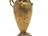 a gold vase that is on a marble base