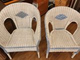 two wicker chairs sitting next to each other on the floor