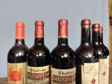 several bottles of wine are lined up on a wooden table