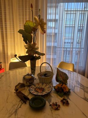a table with a vase of flowers and a plate of food on it