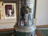 a silver clock sitting on top of a green table