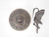 a metal object with a bird on it next to a key