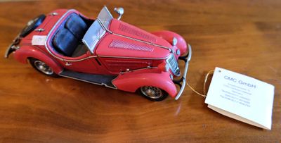 une petite voiture rouge posée sur une table en bois