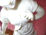 a white statue of a woman holding a flower